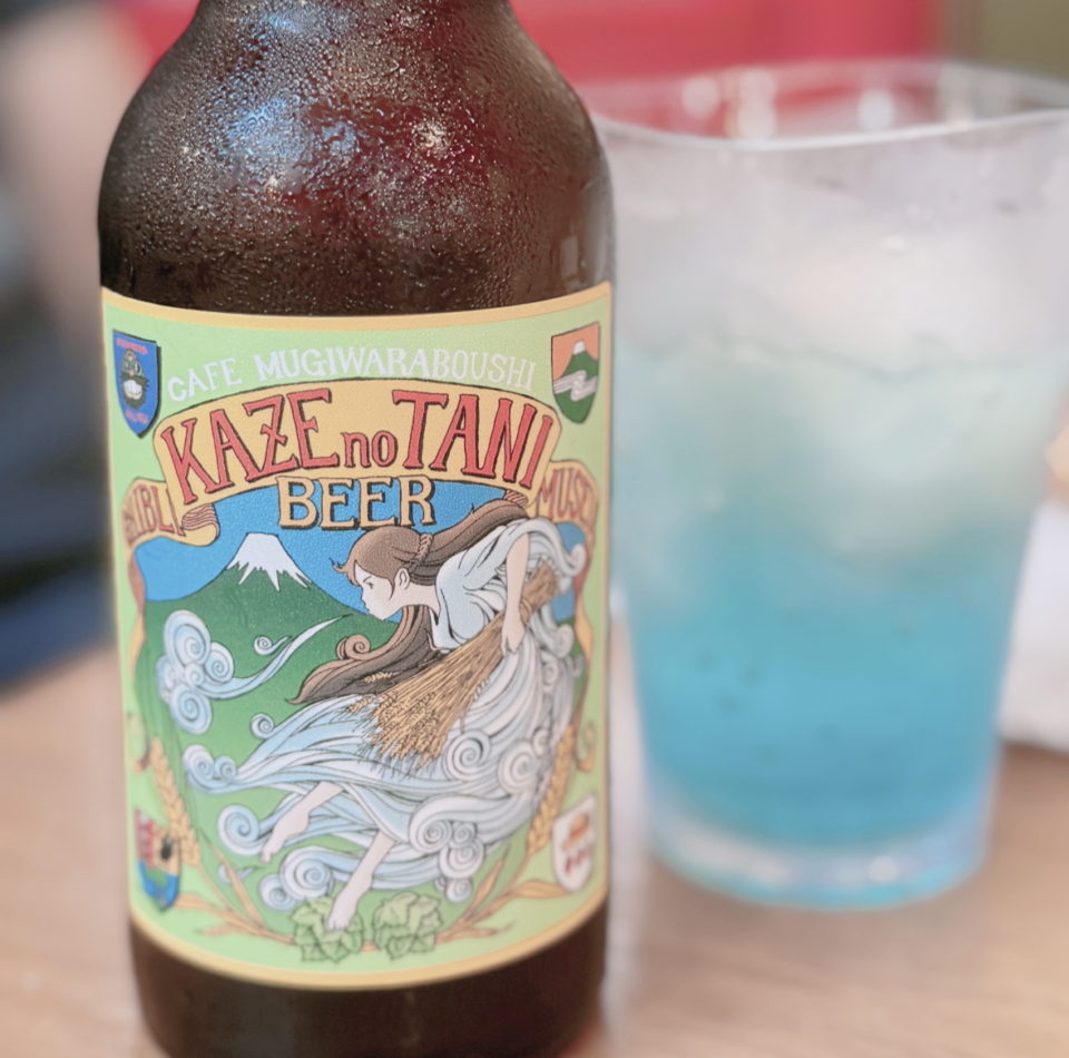 風の谷ビールと書かれたビール瓶に青いソーダが注がれたグラスが置いてある