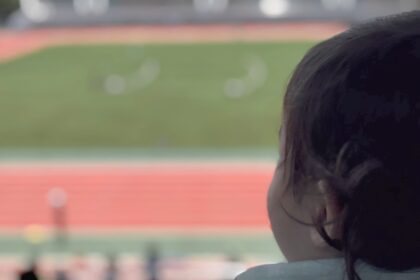 女の子が陸上競技場を見ている