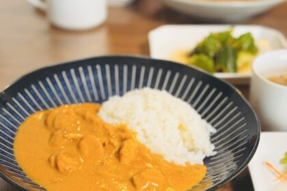 バターチキンカレーとサラダが机に置かれている